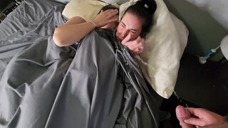 Girls are pissing on a guy who is sleeping with them on the bed