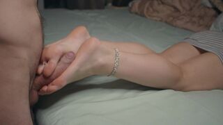 A petite girl is showing off her feet and performing a foot job