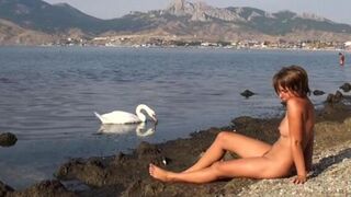 Nudist on the riverbank, a daring outdoor act