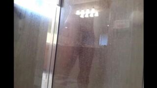 A man washes himself in the shower, unaware of being filmed