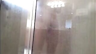 A man washes himself in the shower, unaware of being filmed