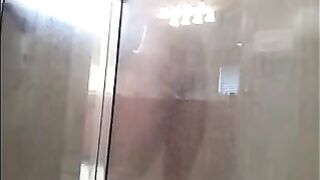 A man washes himself in the shower, unaware of being filmed