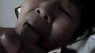An adult Chinese woman practices her blowjob skills on her man in bed