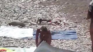 A couple of free-spirited lovers enjoy each other on the nudist beach