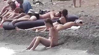 A couple of free-spirited lovers enjoy each other on the nudist beach