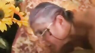 A mature gray-haired woman in black stockings gets fucked hard by a man