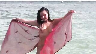 A hot naked girl is having fun in the sea