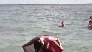 A hot naked girl is having fun in the sea