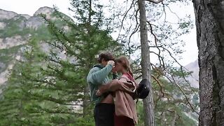 A couple making love outdoors, caught up in a passionate, intimate moment